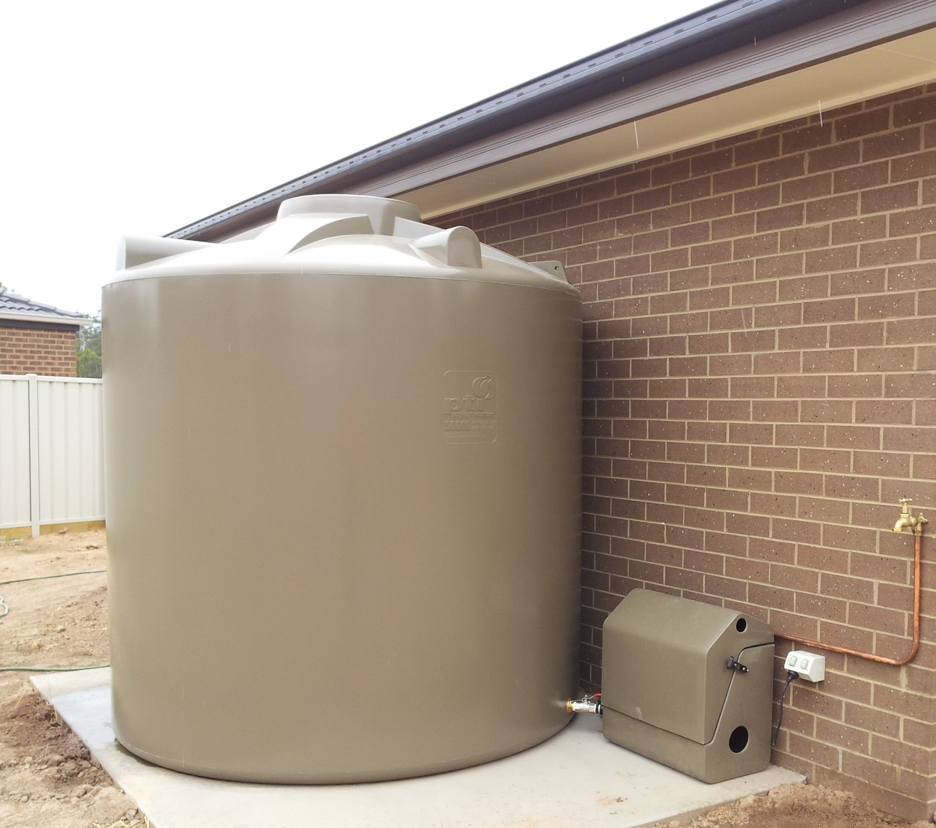 Poly tank against house